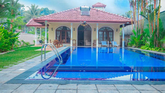 Pool area with a house and garden in the background