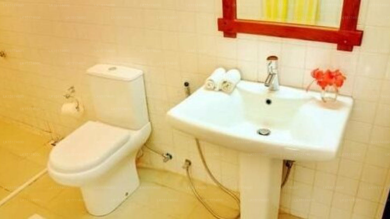 Bathroom with toilet and sink against tiled walls